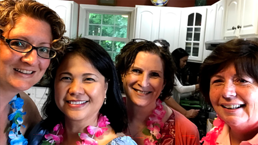 four people in hawaiian shirts posing for a photo