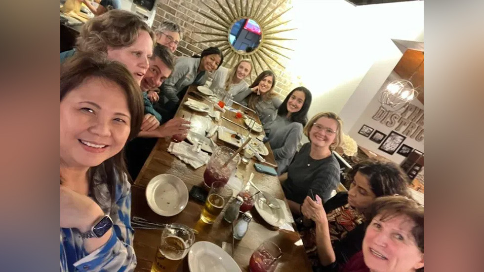 several people posing for a photo at dinner