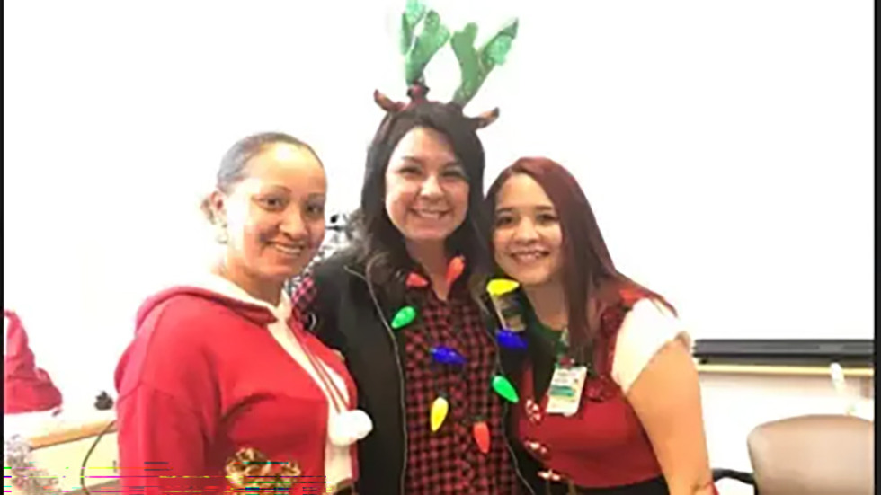 three people in Christmas outfits posing for a photo