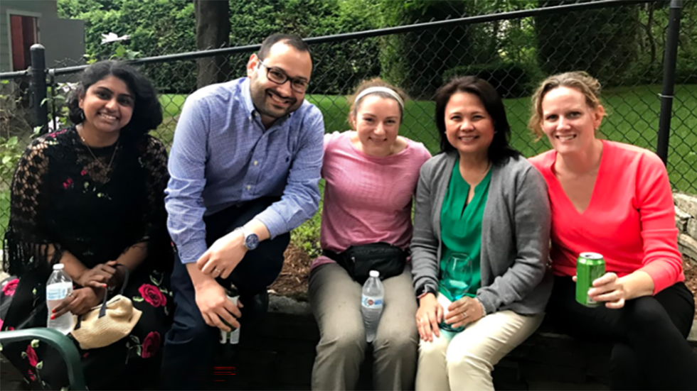 five people sitting outside together
