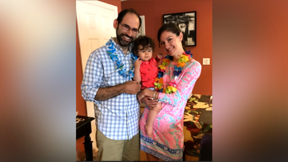 two people holding a baby at a party