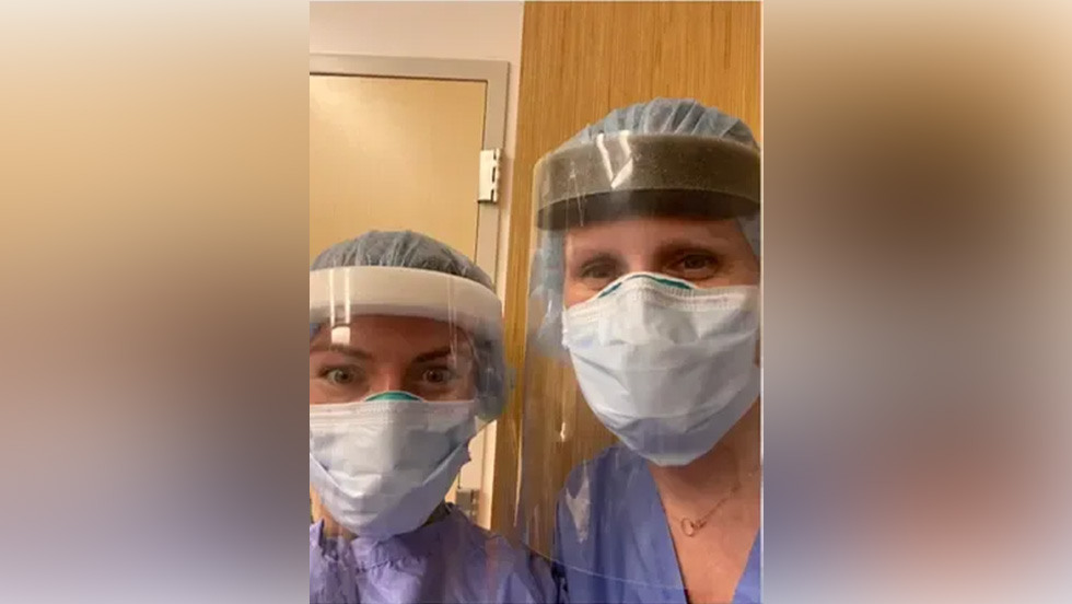 two people in PPE and masks posing together