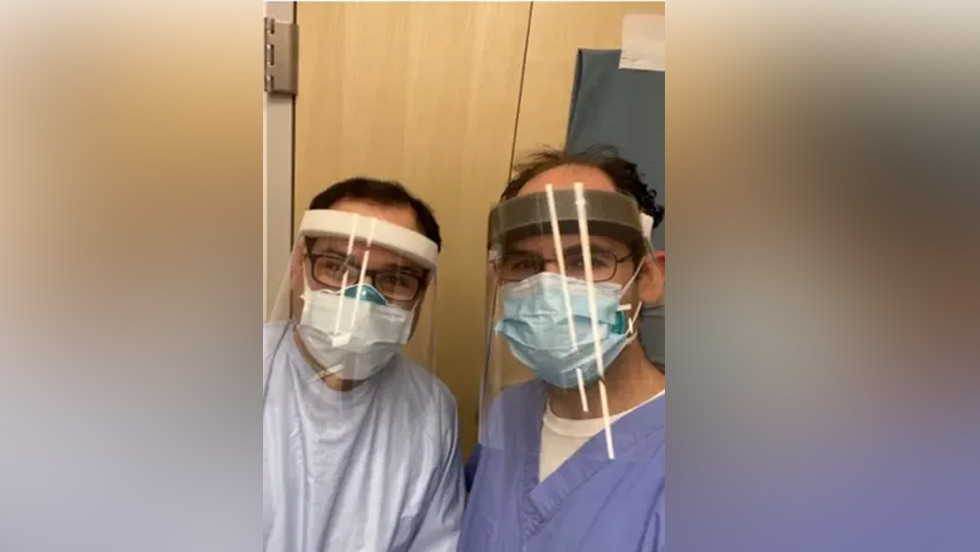 two people in PPE and masks posing for a photo