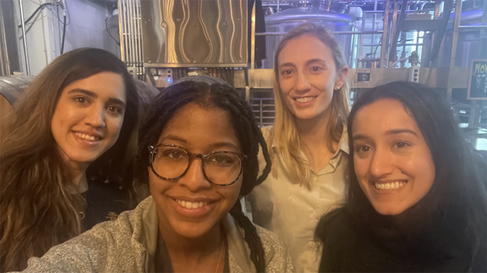 four people taking a selfie at a brewery
