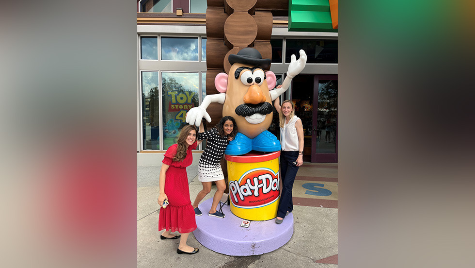 people taking a photo in front of a Mr. Potato Head statue