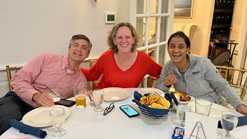 three people sitting together at a table