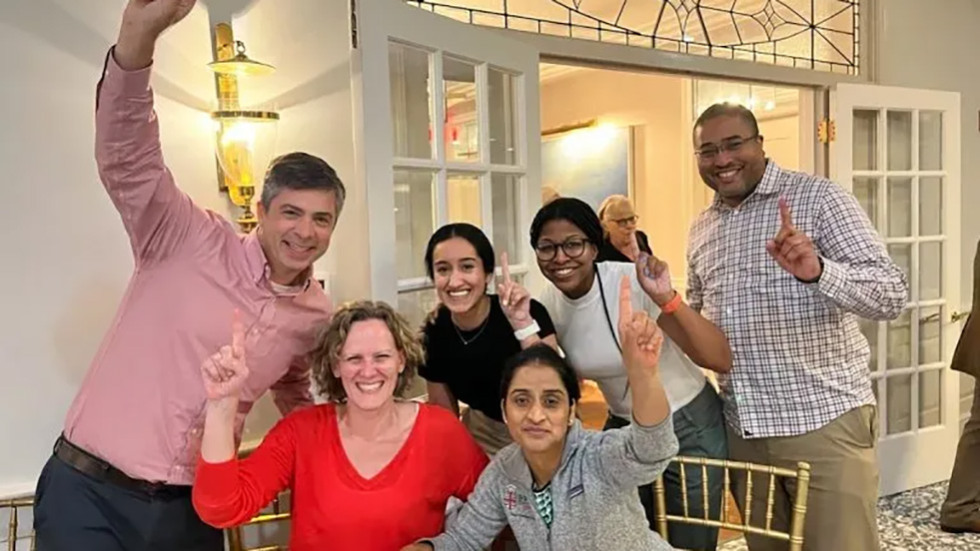 six people cheering together at a table